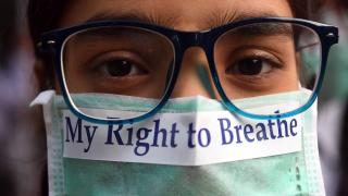 TOPSHOT - An Indian youth wearing a pollution mask participates in a march to raise awareness of air pollution levels in New Delhi on November 15, 2017. - The United Nations Information Centre (UNIC) organised the march to express alarm over the levels of air pollution in the city (Photo by PRAKASH SINGH / AFP) (Photo by PRAKASH SINGH/AFP via Getty Images)